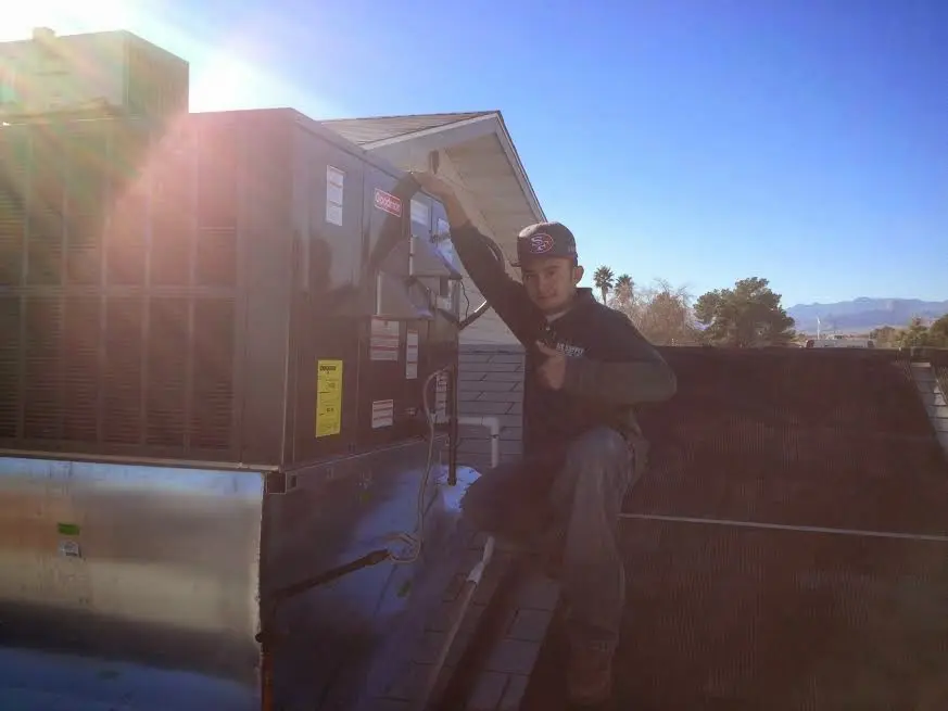 HVAC technician performing Boiler Repair on a rooftop unit in Hendersonville